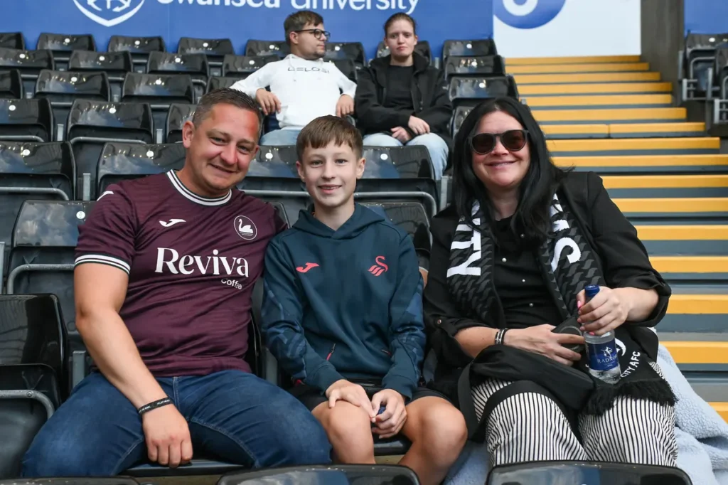 Family of Swansea City supporters in their seats